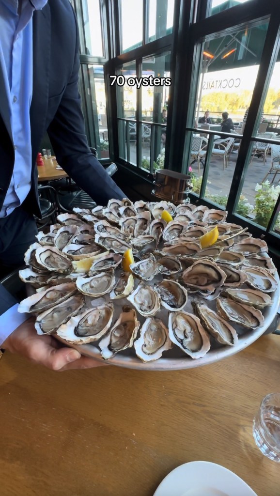 Georgiana described her bivalve binge as "the best breakfast of my entire life." A server brings the surprisingly large tray of oysters to her table in the photo above.