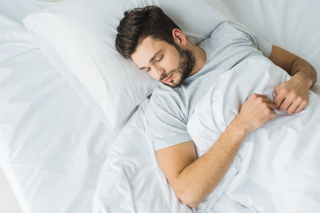 A man sleeps well in bed.