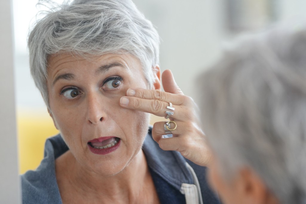 Elderly woman looking at eye wrinkles