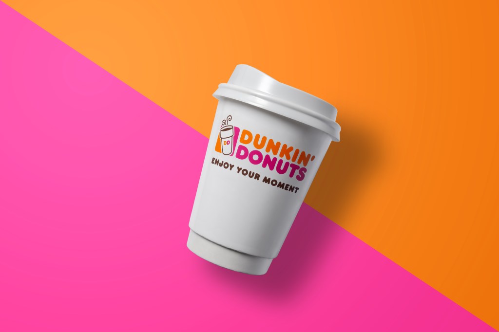 Dunkin donuts cup hot brown on a colorful pink and orange background