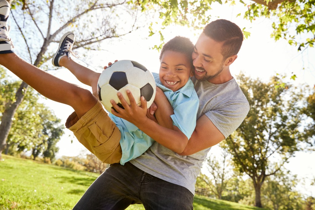 Dad playing football with the boy
