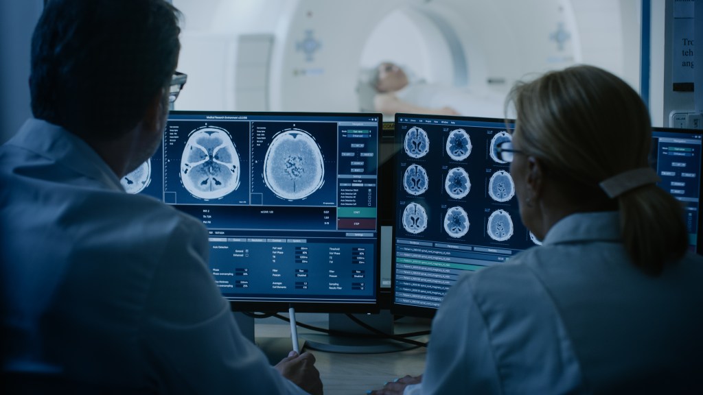 Doctors analyze images of a brain taken from a CT scan.
