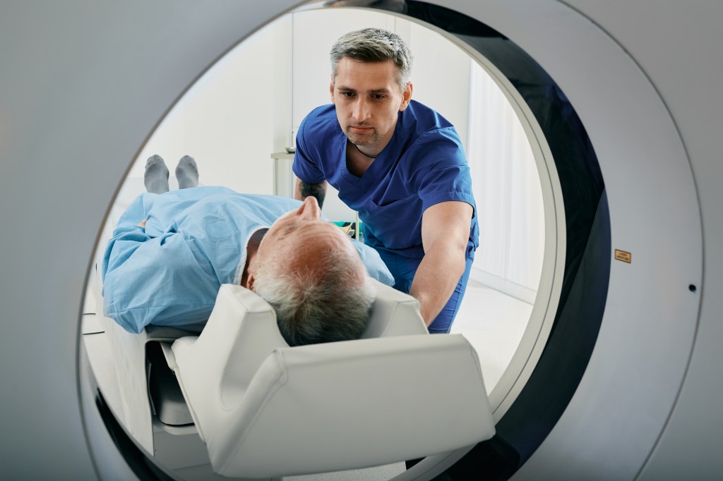 An elderly man undergoes a CT scan.