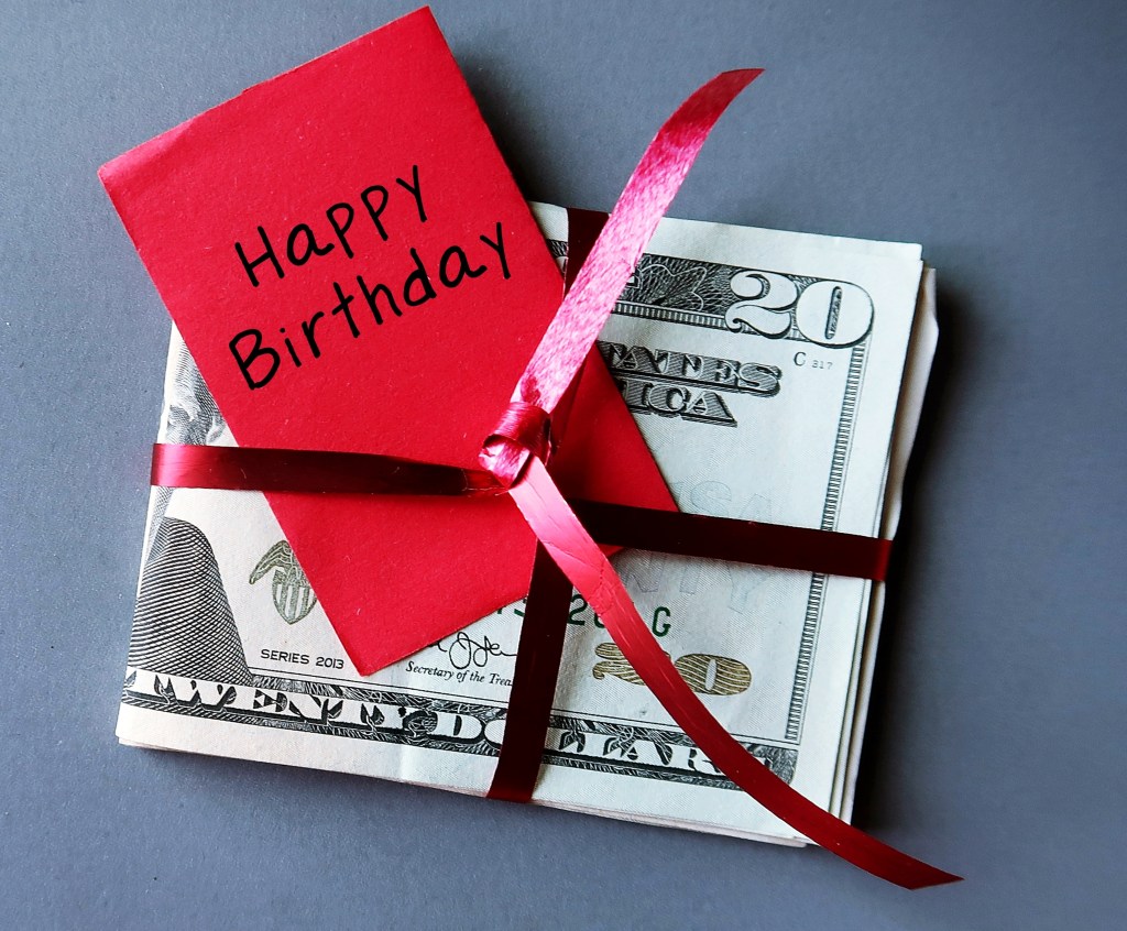 Money Money Money Money in Red Ribbon with Red Written Textbook Written Birthday - the concept of birthday money gifts giving loved ones