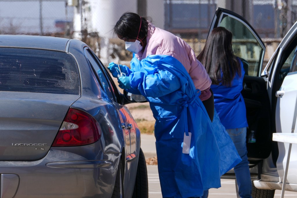 A health worker manages a measles test for a car passenger in a mobile test site outside the Hospital County on Friday, February 21, 2025, in Seminole, Texas.
