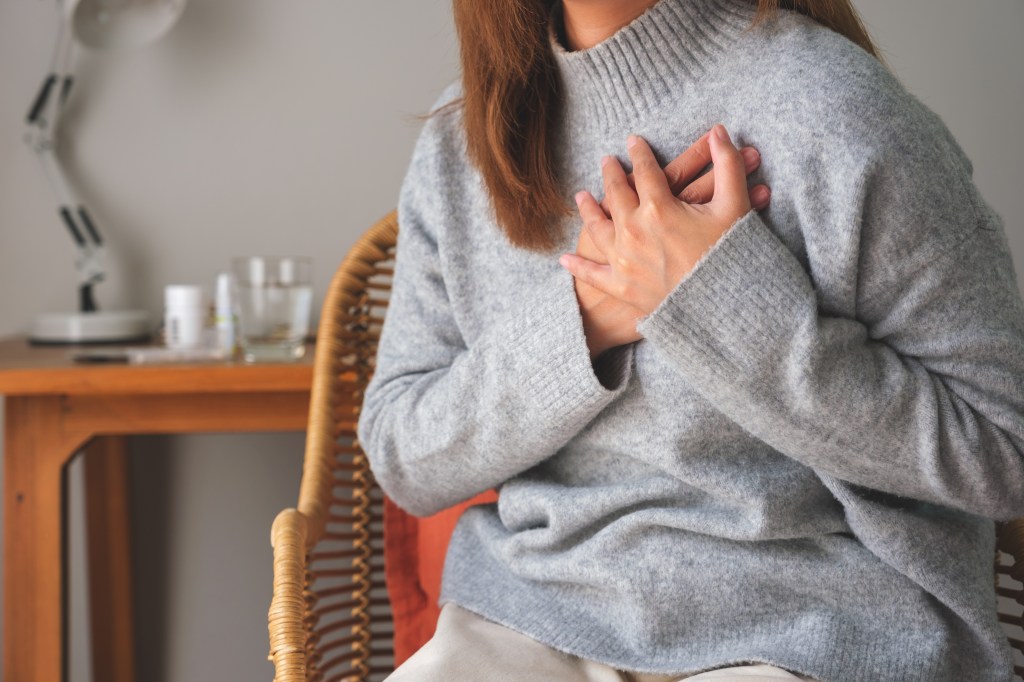 A woman tightens her chest as she experiences pain.