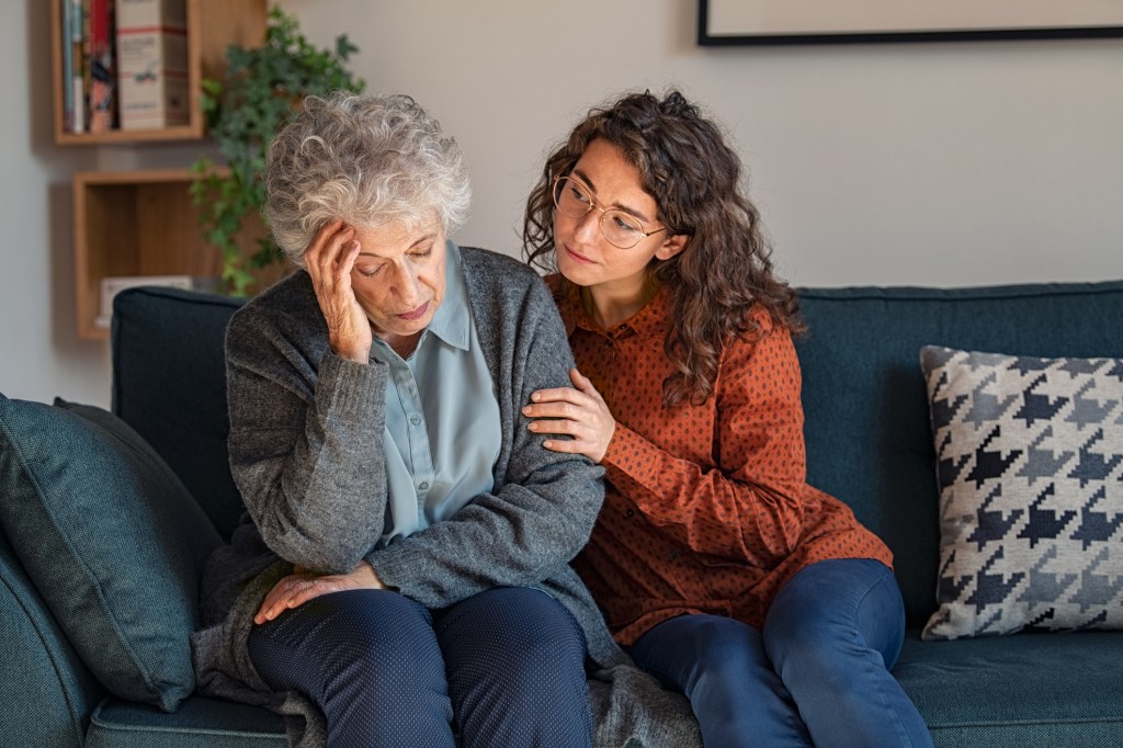The girl comforts the elderly woman with dementia